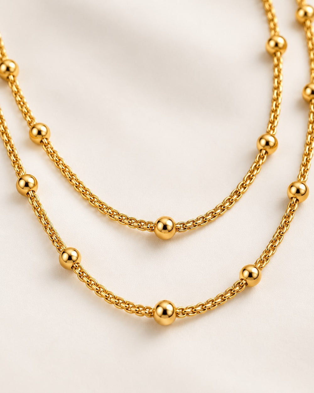 Elli Jewellery gold plated triple layered beaded chain necklace with delicate gold beads on a white background