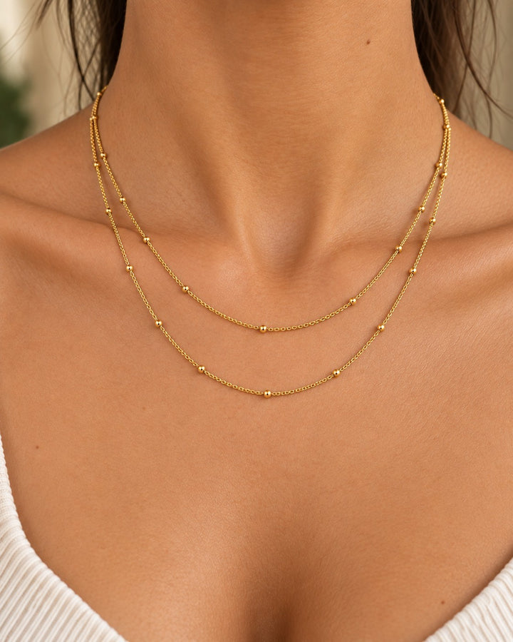 Elli Jewellery gold plated waterproof triple layered beaded chain necklace worn on a model