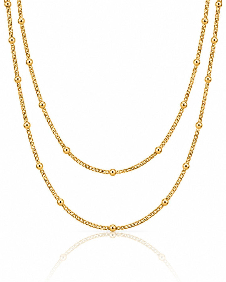 Elli Jewellery gold plated triple layered beaded chain necklace with delicate spheres on a white background