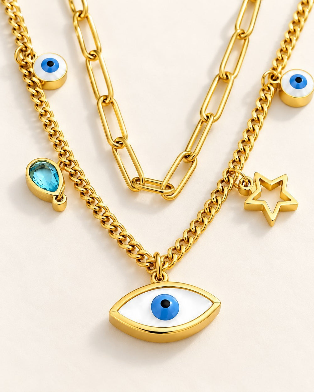 Elli Jewellery gold plated layered necklace with paperclip chain, evil eye charms, star pendant, and blue crystal.