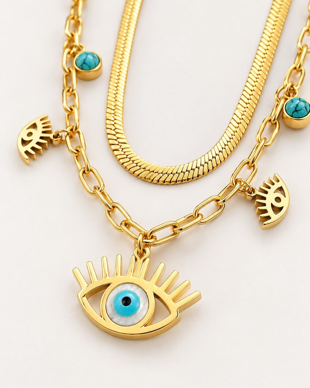 Elli Jewellery gold plated layered necklace featuring a snake chain, paperclip chain, and evil eye charms with turquoise
