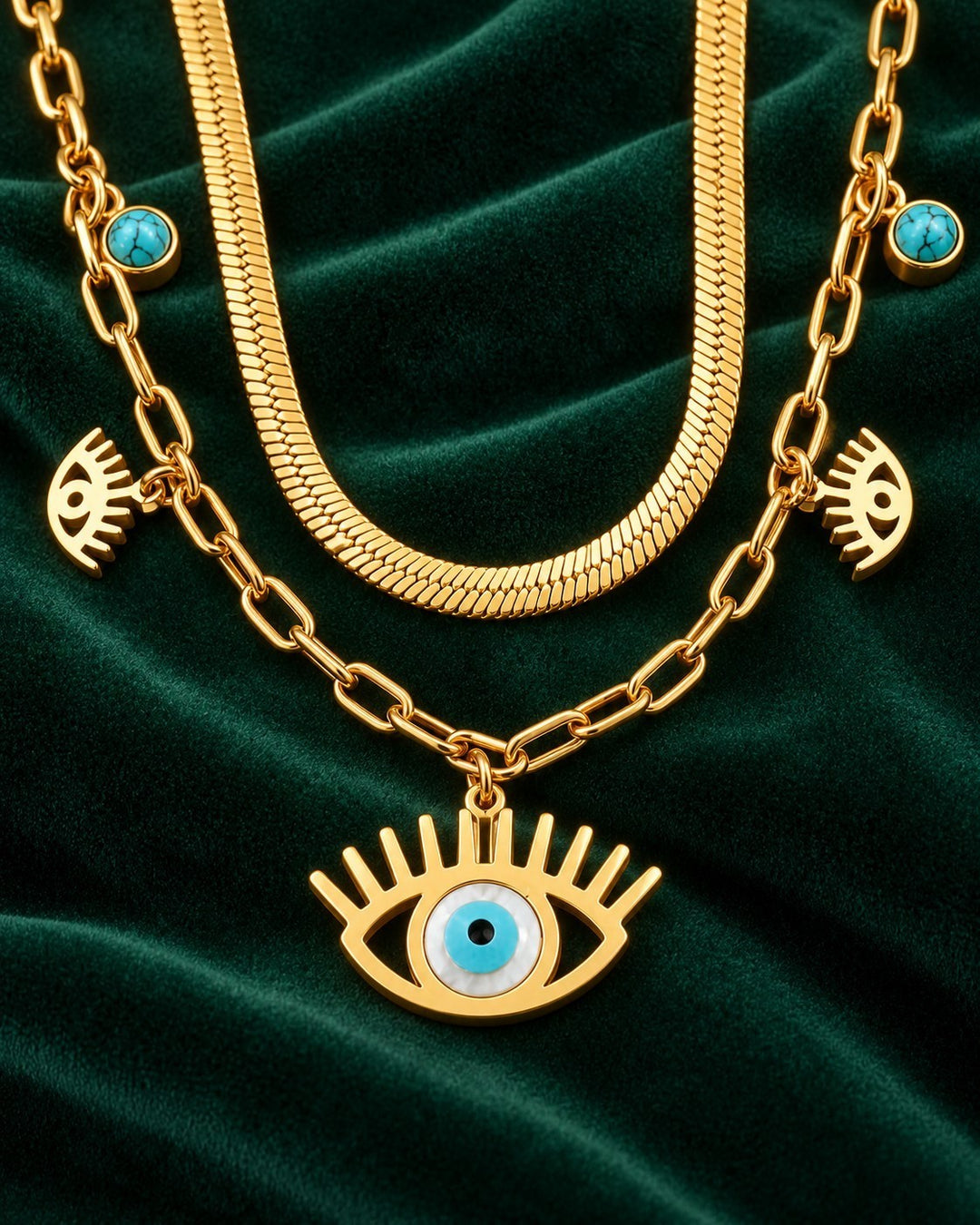 Elli Jewellery gold plated layered necklace featuring a snake chain, paperclip chain, and evil eye charms on velvet.