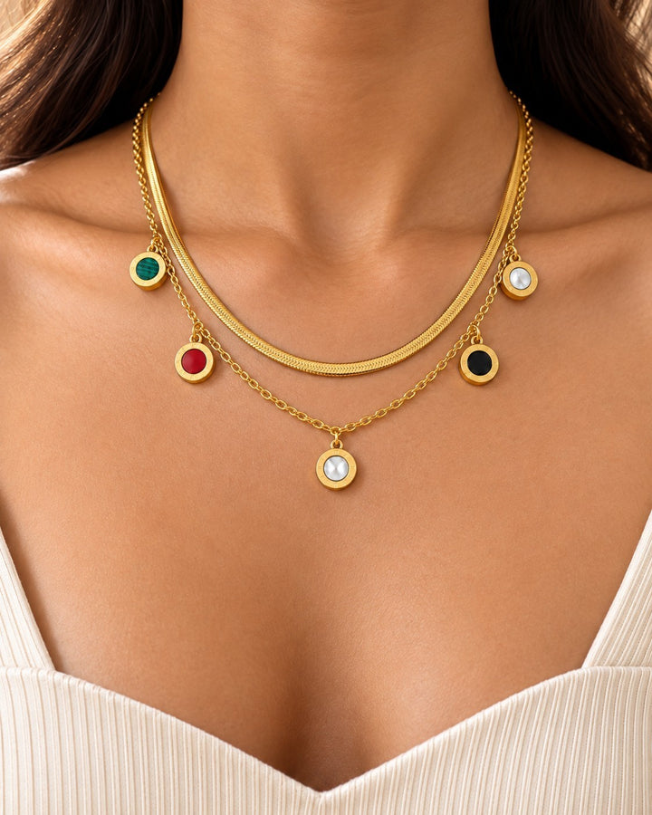 Elli Jewellery gold plated layered snake chain necklace with multicoloured circular beaded charms on a model