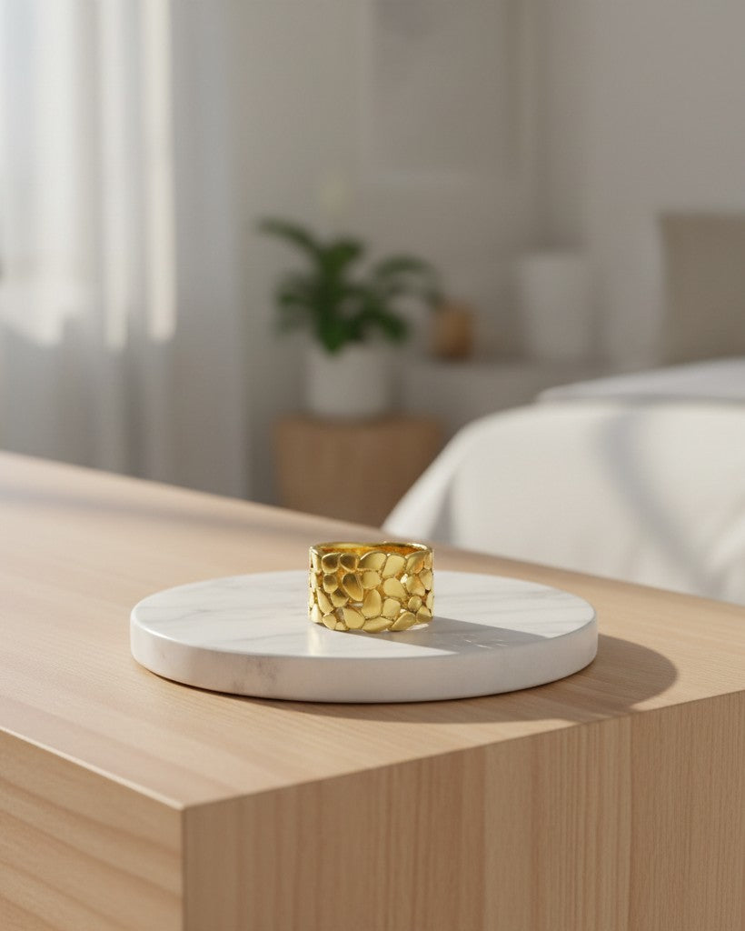 Elli Jewellery gold plated hollow leaf band ring with textured botanical design on a white marble display stand.