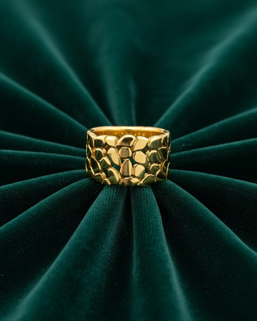 Elli Jewellery gold plated band ring featuring a delicate hollow leaf pattern on a dark green velvet background.