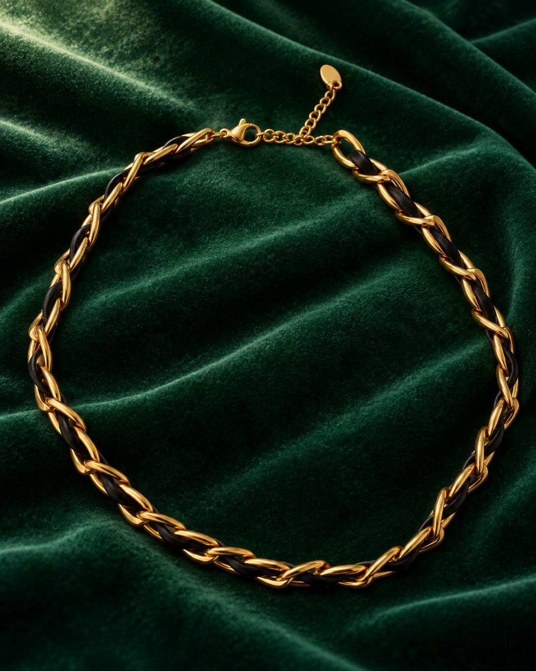 Elli Jewellery gold-plated curb chain necklace interwoven with black leather on a dark green velvet background