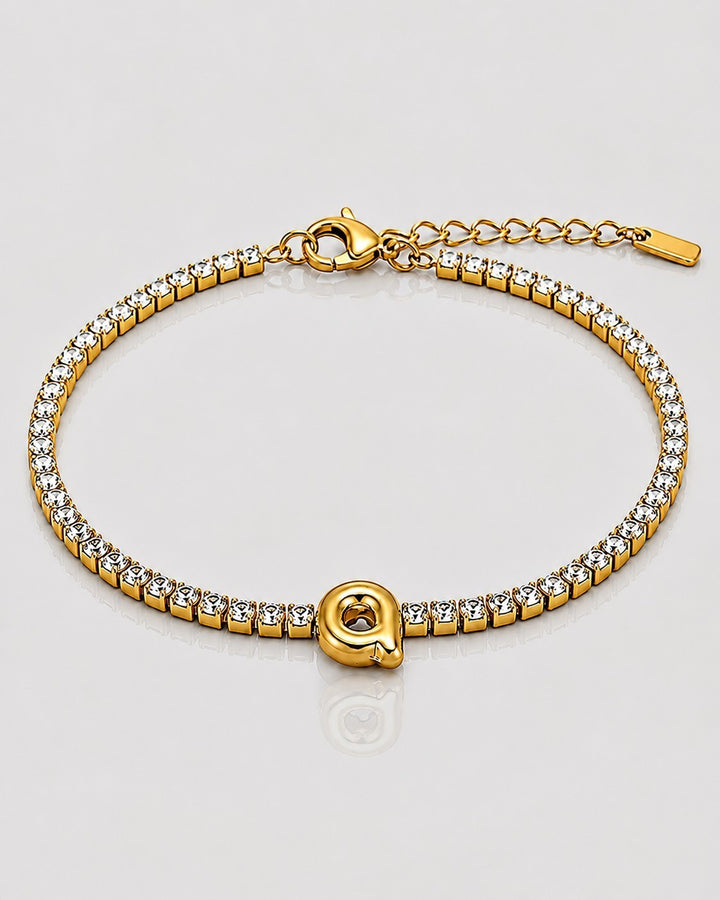 Elli Jewellery gold plated waterproof tennis bracelet featuring a central letter Q charm and sparkling crystal stones.
