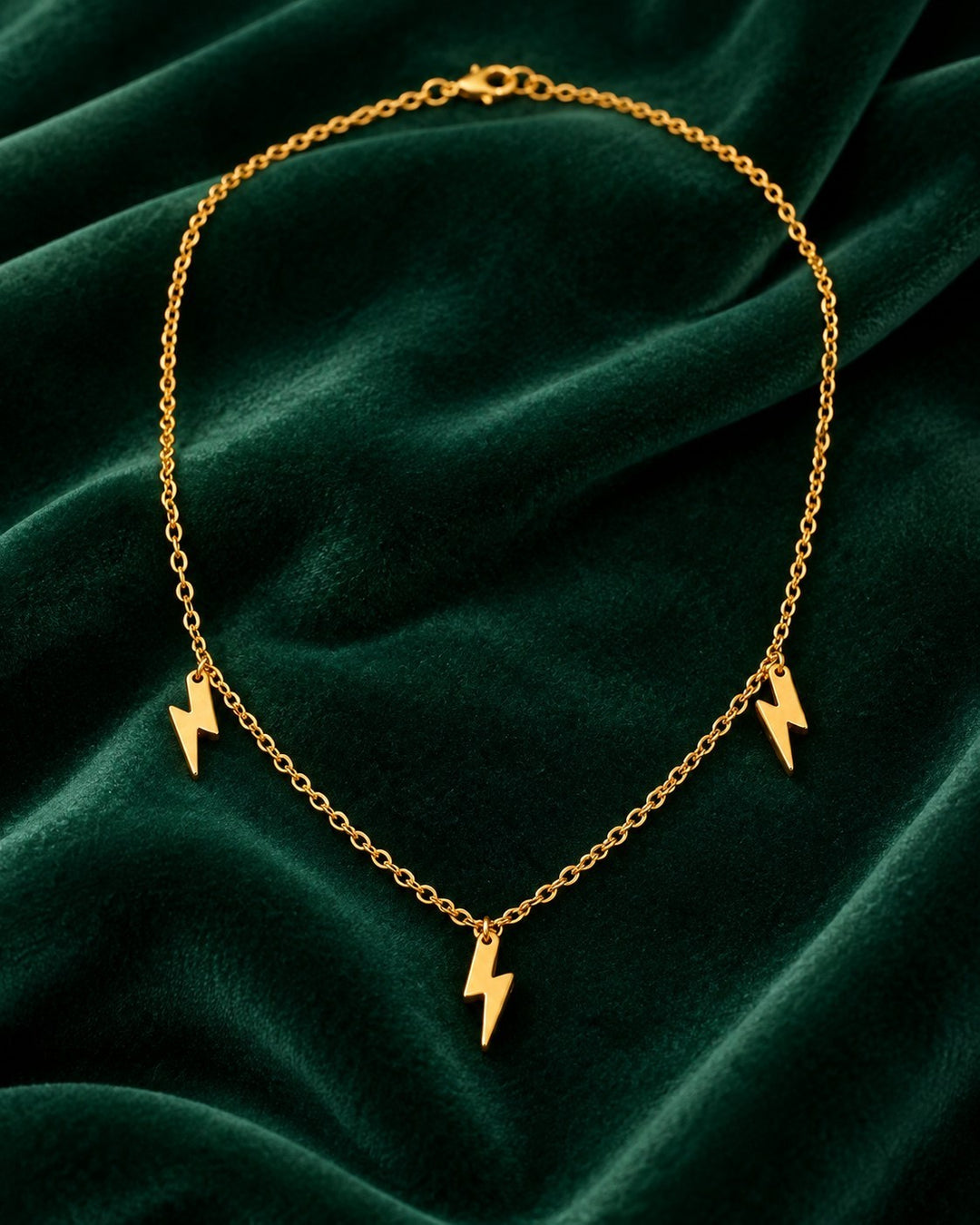 Elli Jewellery gold plated waterproof necklace featuring three small lightning bolt charms on a delicate chain