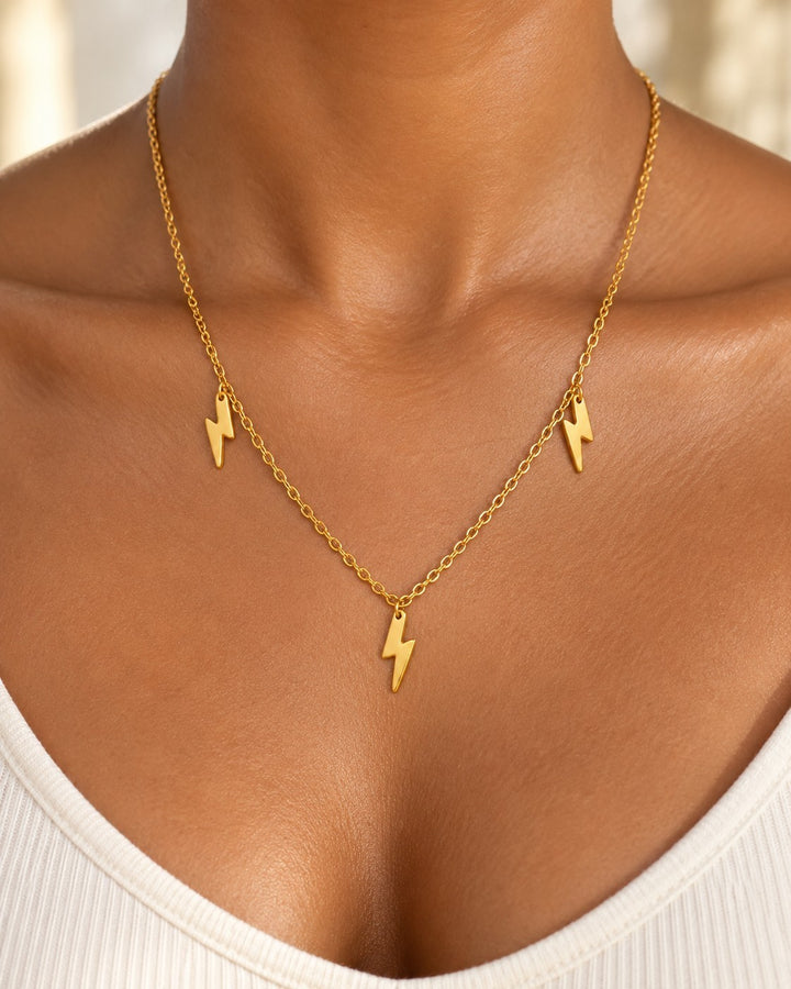 Elli Jewellery gold plated necklace featuring three delicate lightning bolt charms on a fine chain worn on a model