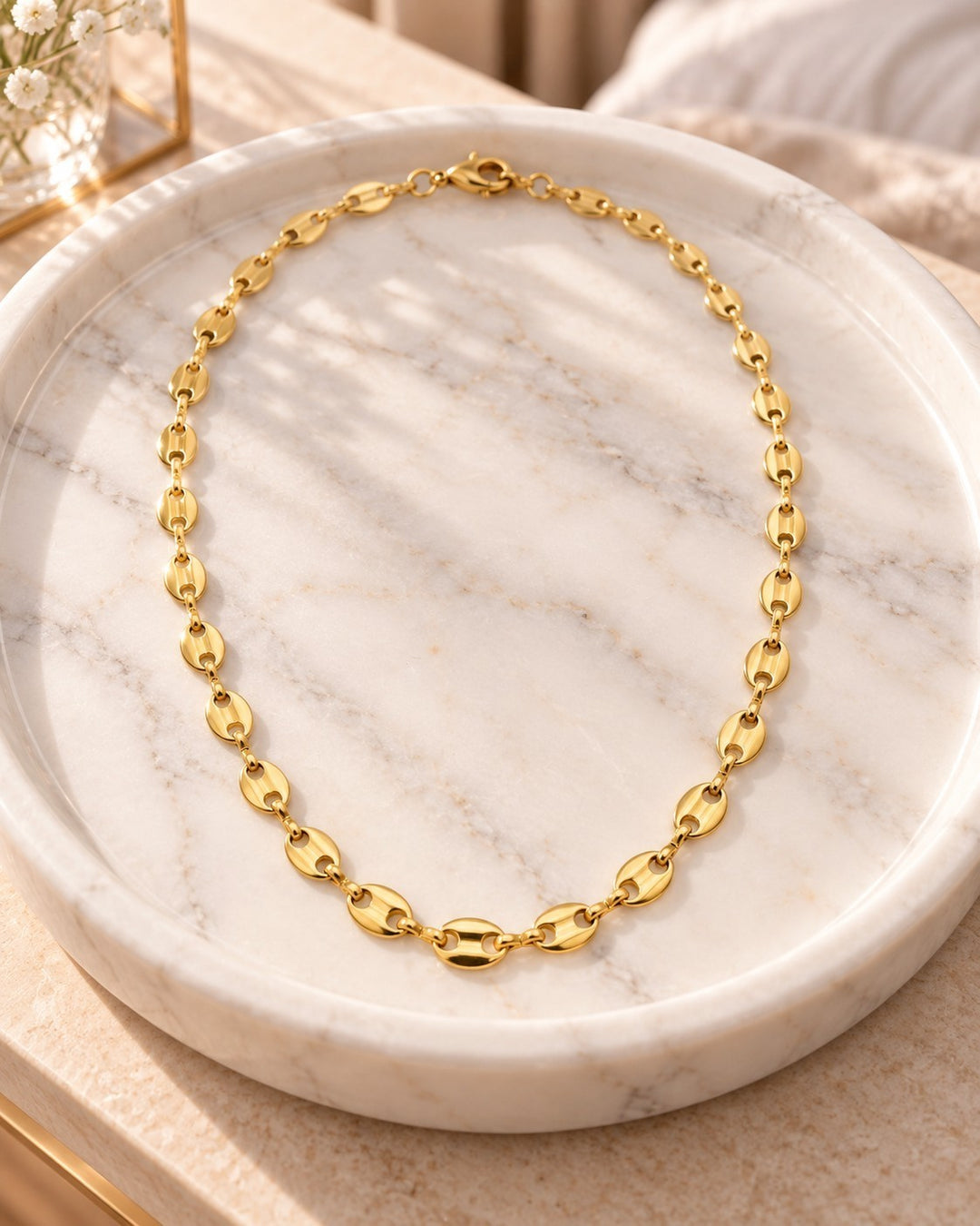 Elli Jewellery gold plated waterproof link chain choker necklace displayed on a white marble tray.