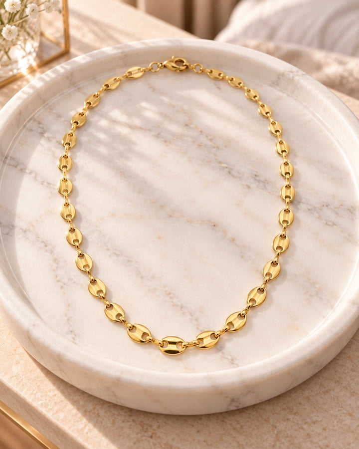 Elli Jewellery gold plated waterproof link chain choker necklace displayed on a white marble tray.