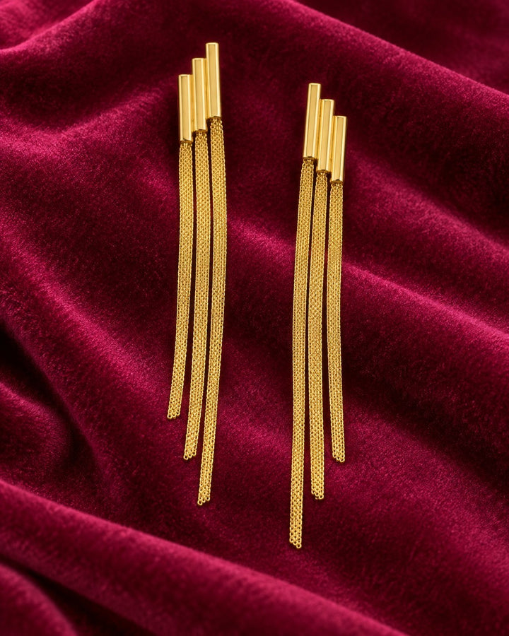 Elli Jewellery gold plated long drop chain earrings with a sleek, tarnish-free finish on a deep red velvet background.