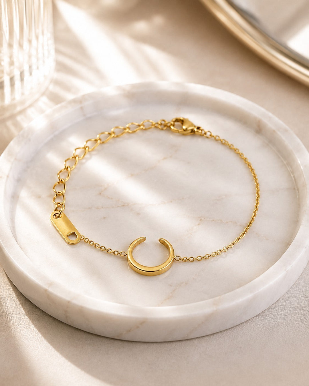 Elli Jewellery gold plated minimalist chain bracelet with a crescent charm on a marble tray