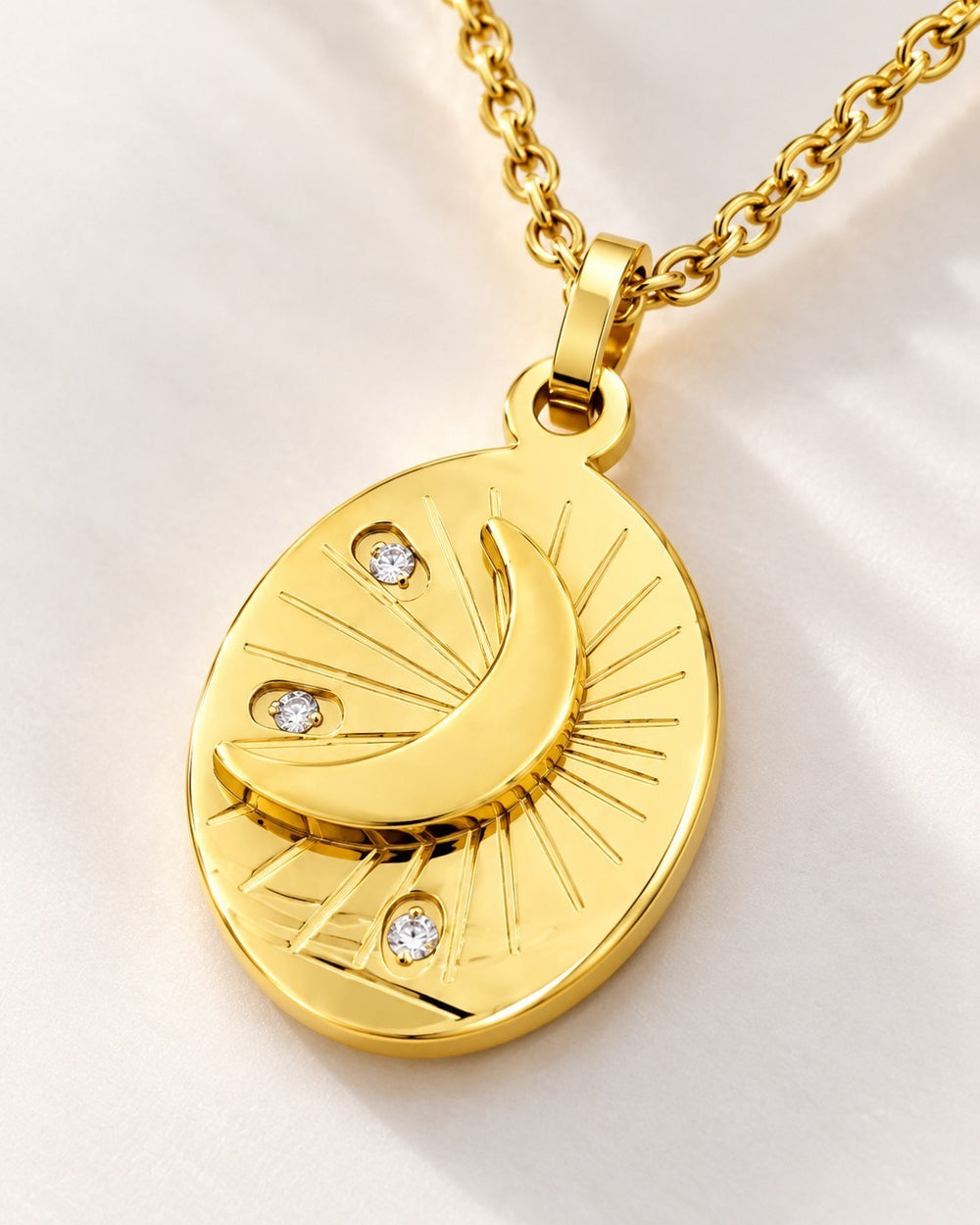 Elli Jewellery gold plated oval pendant necklace featuring a crescent moon, star motifs, and sparkling crystal accents.