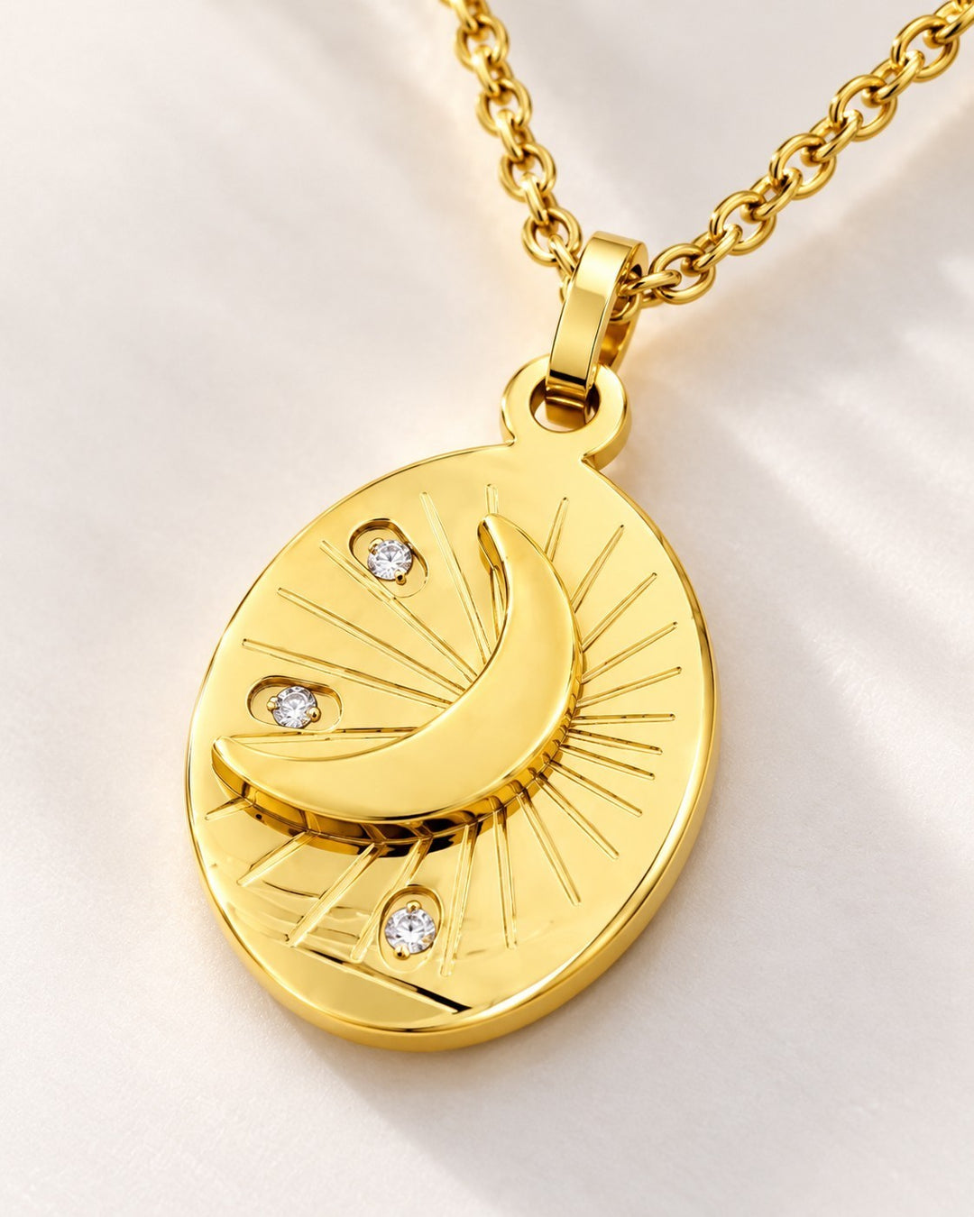 Elli Jewellery gold plated oval pendant necklace featuring a crescent moon, star motifs, and sparkling crystal accents.
