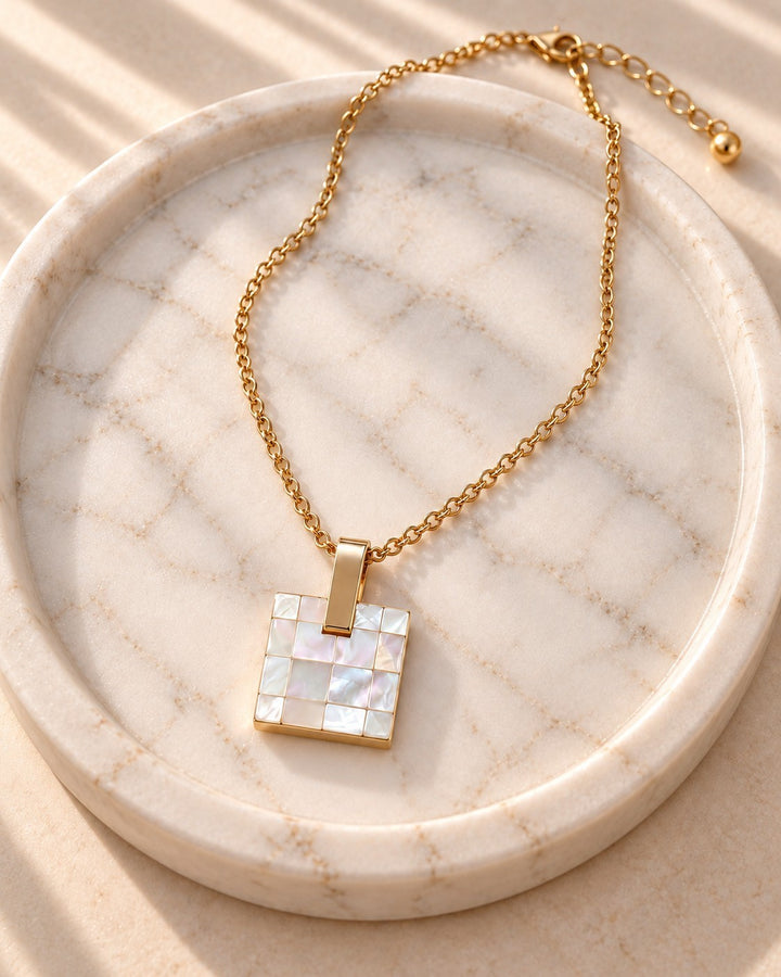 Elli Jewellery gold plated square pendant necklace featuring a mosaic mother-of-pearl shell inlay on a marble tray.