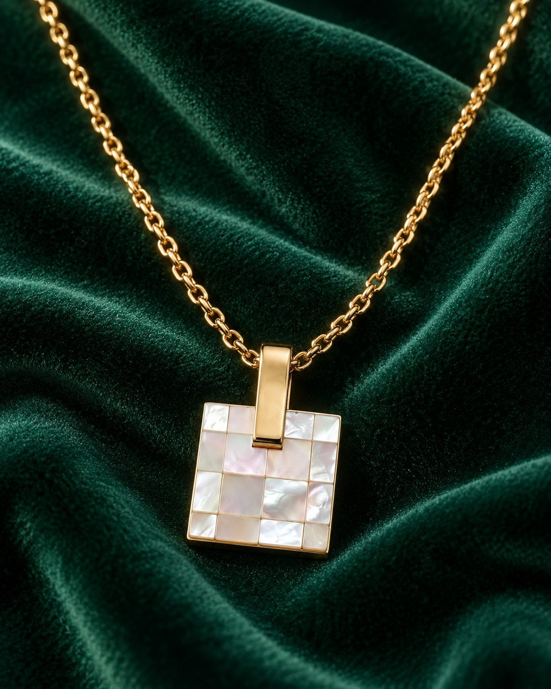 Elli Jewellery gold-plated square pendant necklace featuring a mosaic mother-of-pearl shell inlay on green velvet.