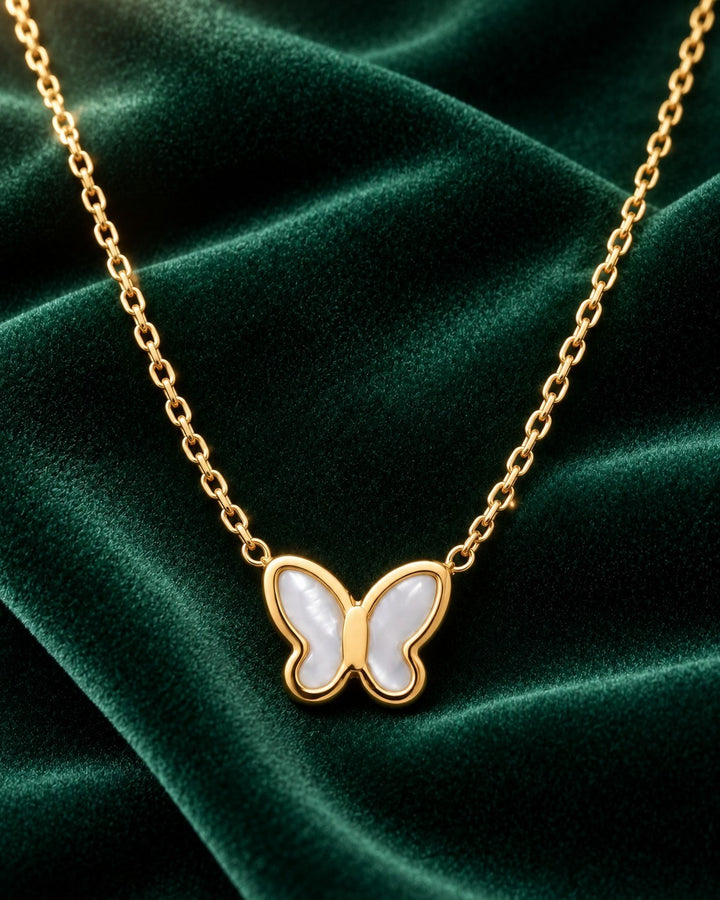 Elli Jewellery gold plated butterfly pendant necklace with iridescent mother of pearl inlay on green velvet fabric