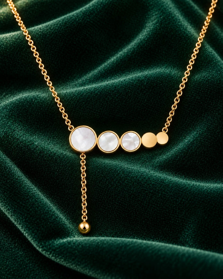 Elli Jewellery gold plated necklace featuring a row of mother of pearl circles and a delicate dangling chain charm.