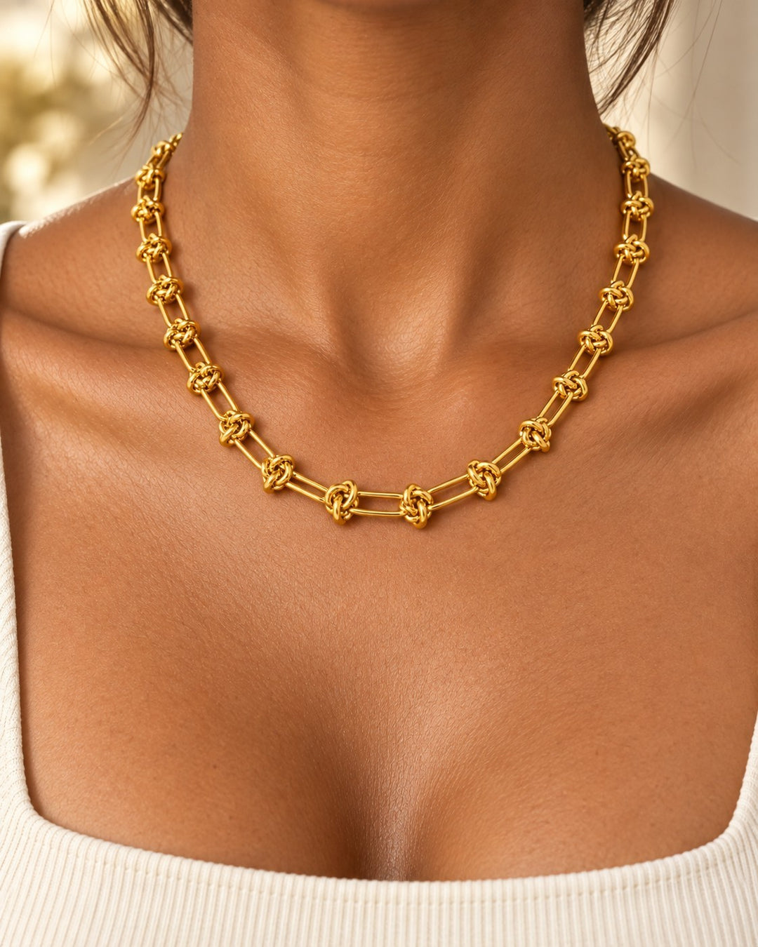 Elli Jewellery gold plated waterproof oval link chain necklace worn on a model with a white top