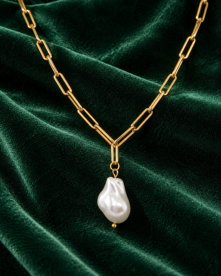 Elli Jewellery gold plated paperclip chain necklace featuring a lustrous baroque faux pearl pendant on green velvet.