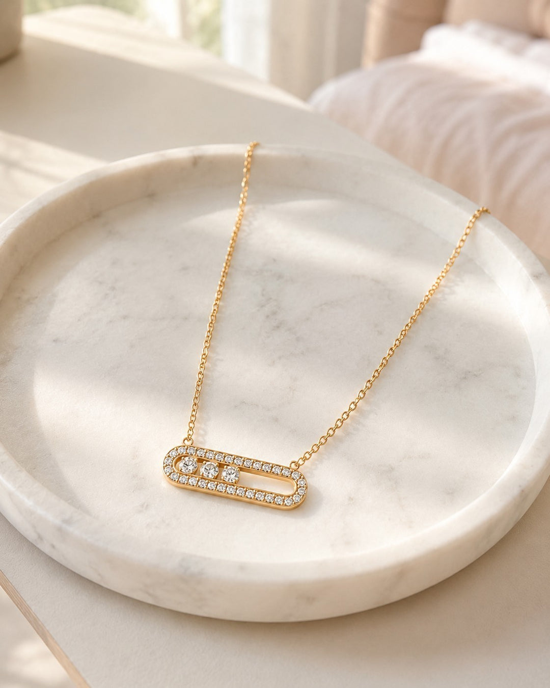Elli Jewellery gold plated necklace with an elongated oval pendant featuring pavé crystals on a marble tray