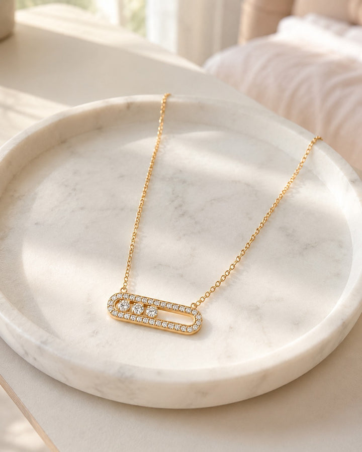 Elli Jewellery gold plated necklace with an elongated oval pendant featuring pavé crystals on a marble tray