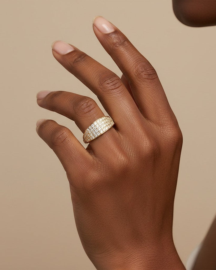 Elli Jewellery gold plated waterproof ring featuring a wide band with pavé crystal settings on a model's finger
