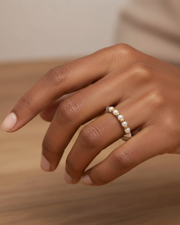 Elli Jewellery gold plated statement ring featuring alternating freshwater pearl beads on a model's finger.