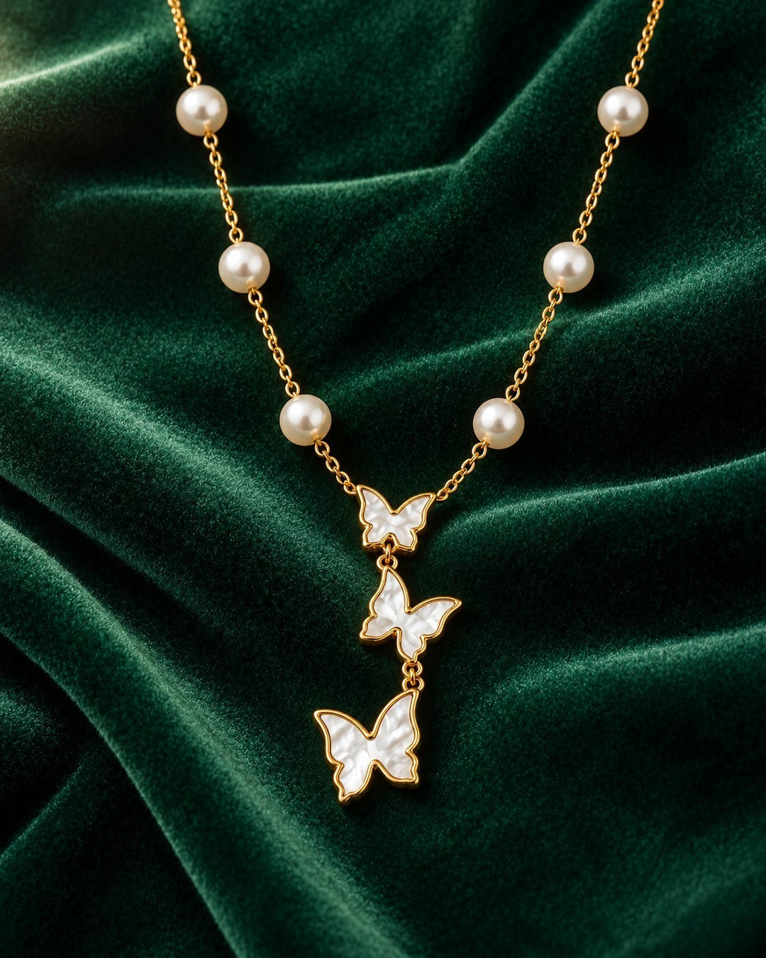 Elli Jewellery gold plated necklace featuring three mother of pearl butterfly pendants and delicate pearl accents.