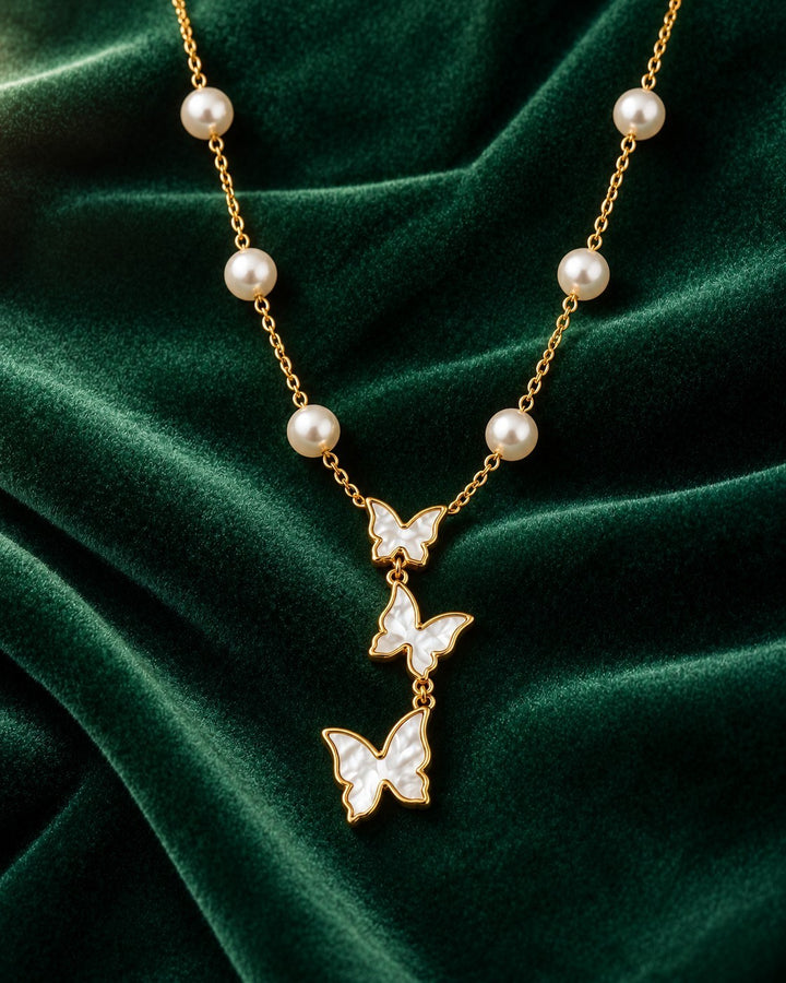 Elli Jewellery gold plated necklace featuring three mother of pearl butterfly pendants and delicate pearl accents.