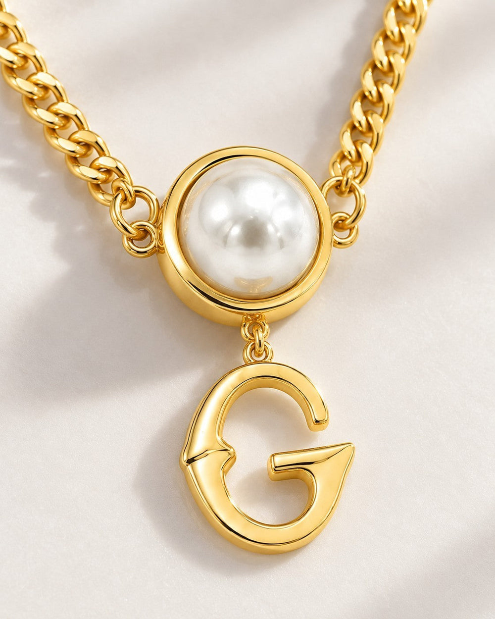 Elli Jewellery gold plated curb chain necklace featuring a white pearl pendant and a dangling letter G charm.