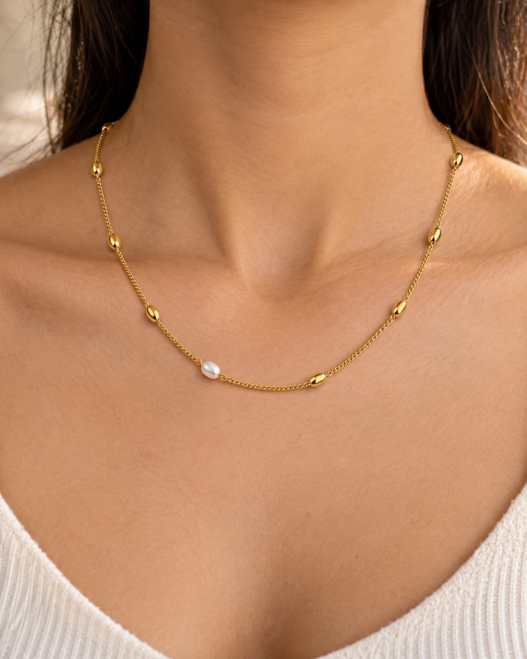 Elli Jewellery gold plated chain necklace featuring delicate freshwater pearl beads worn on a model