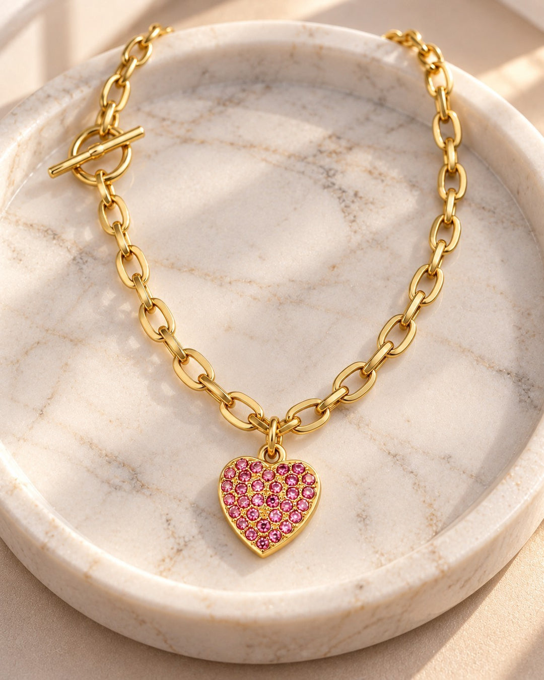 Elli Jewellery gold plated T-bar necklace featuring a pink diamante heart pendant on a chunky link chain.