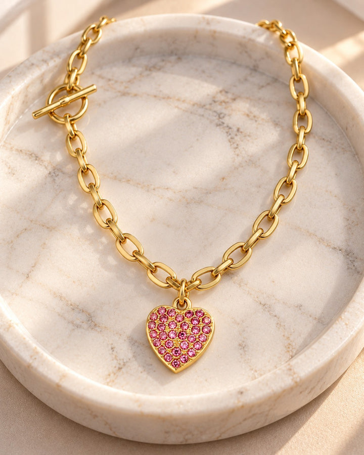 Elli Jewellery gold plated T-bar necklace featuring a pink diamante heart pendant on a chunky link chain.