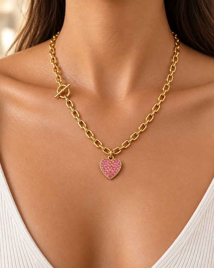 Elli Jewellery gold plated chain necklace featuring a pink diamante heart pendant and a modern T-bar clasp detail.