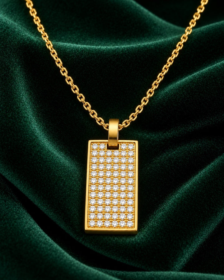 Elli Jewellery gold plated rectangle pendant necklace with a geometric crystal inlay on a dark green velvet background