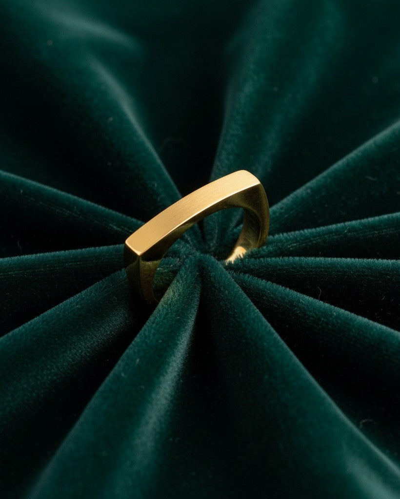 Elli Jewellery gold plated rectangular signet ring for men, featuring a polished finish on dark green velvet.