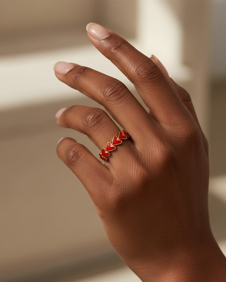 Elli Jewellery gold plated ring featuring a cluster of vibrant red enamel hearts worn on a finger