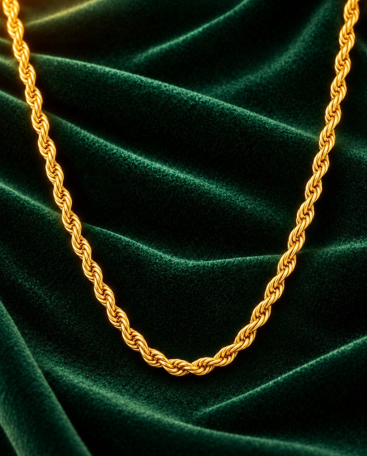 Elli Jewellery gold plated chunky rope chain necklace resting on a luxurious dark green velvet fabric background.