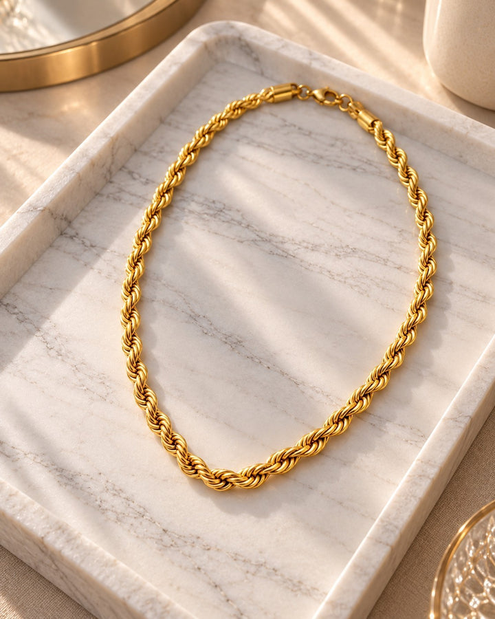 Elli Jewellery gold plated waterproof rope chain necklace with a textured twisted design on a marble tray.