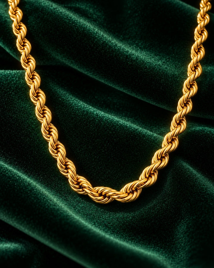 Elli Jewellery gold plated waterproof rope chain necklace with a textured twisted design on a dark green velvet background
