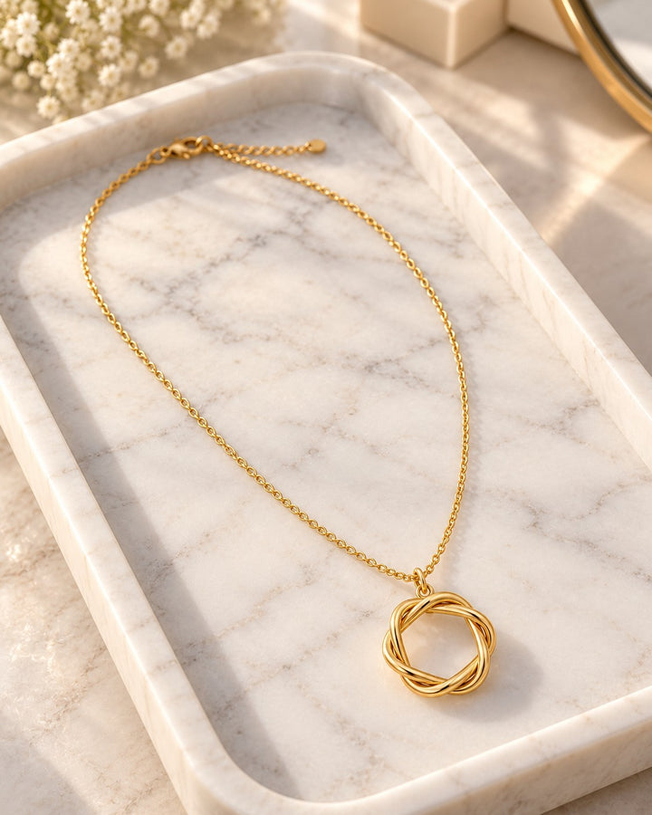 Elli Jewellery gold plated necklace featuring a textured rope-style circle pendant on a delicate chain on marble tray