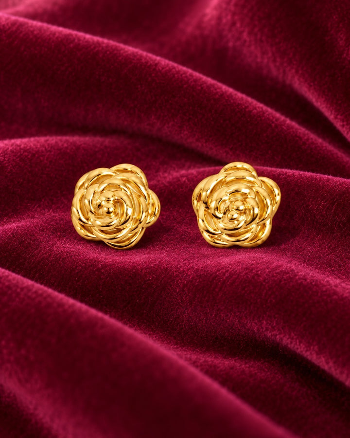 Elli Jewellery rosette stud earrings in 18ct gold plated brass featuring dimensional flower petals on red velvet.