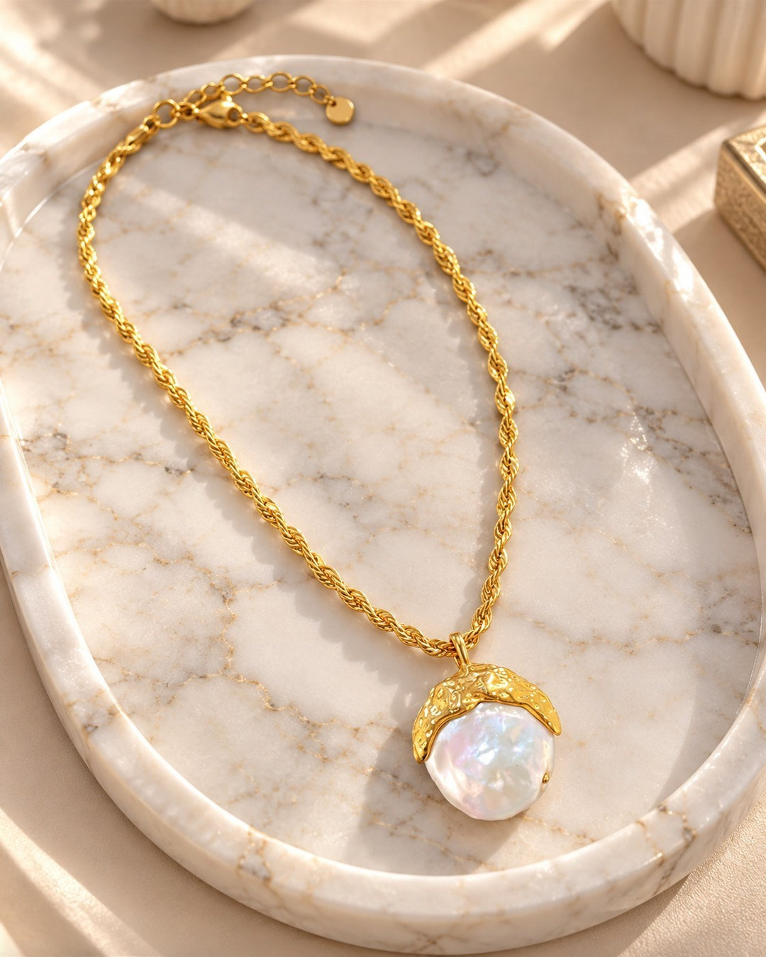 Elli Jewellery gold-plated rope chain necklace featuring a lustrous shell pearl pendant on a marble display tray.