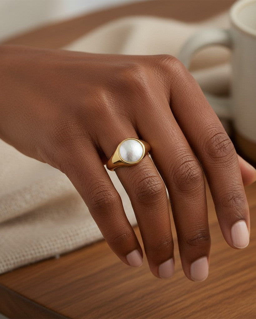 Elli Jewellery gold toned chunky ring with a smooth white shell inlay worn on a model's hand