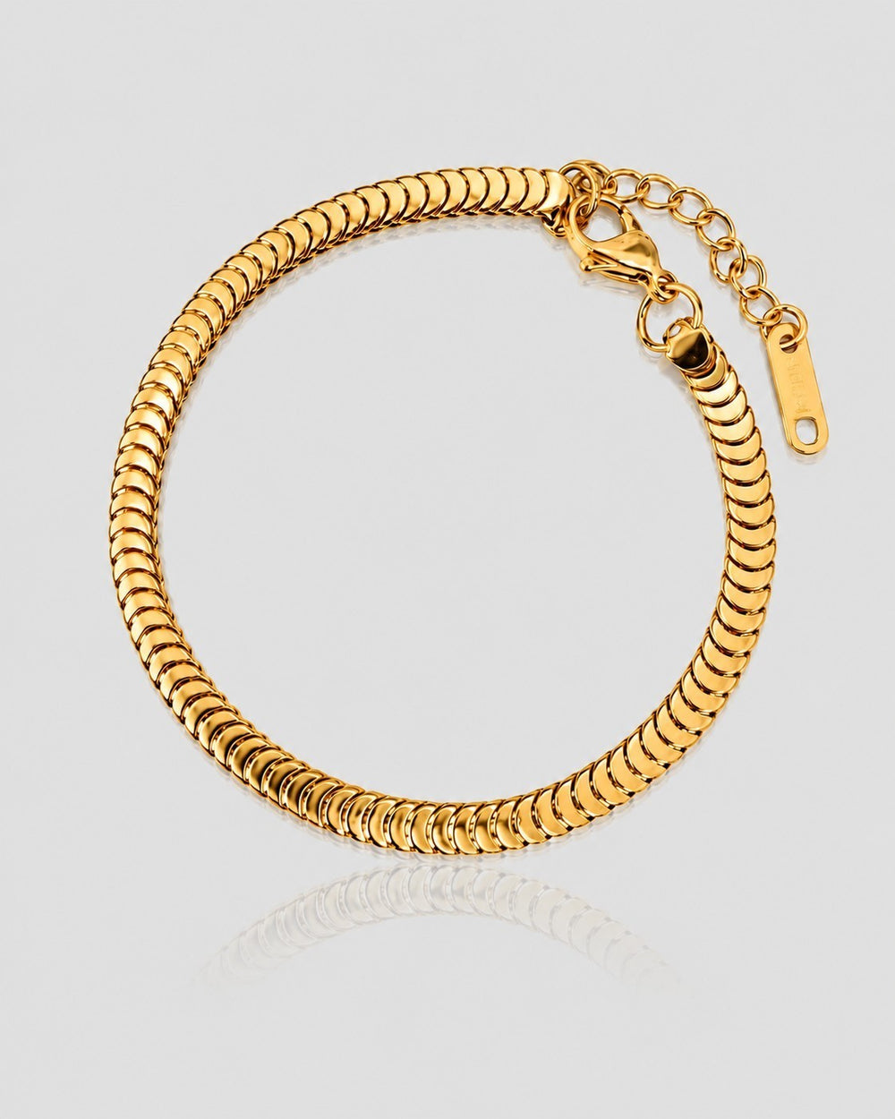 Elli Jewellery gold plated snake disc chain bracelet with adjustable extender and lobster clasp on a reflective surface