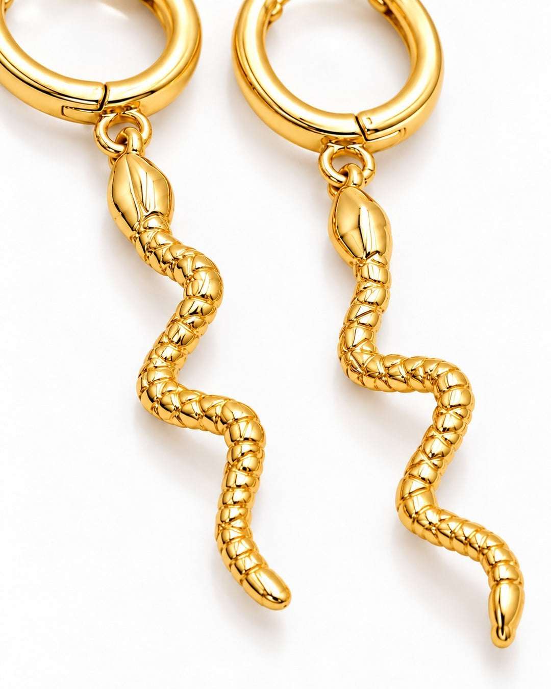 Elli Jewellery gold plated huggie hoop earrings featuring a detailed snake texture design on a white background.