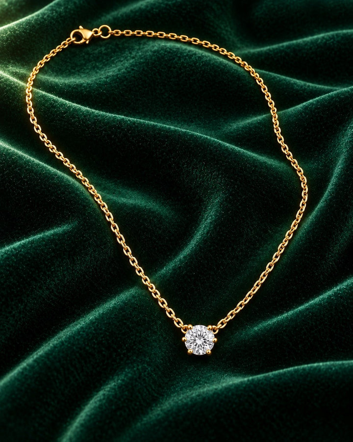 Elli Jewellery gold plated solitaire cubic zirconia pendant necklace on a dark green velvet background