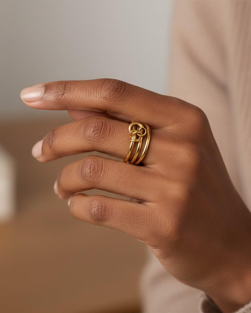 Elli Jewellery gold plated multilayer stacked ring with a knot detail worn on a woman's finger